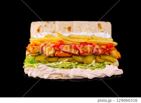 Delicious wrap filled with grilled chicken, fresh vegetables, and sauces 129060316