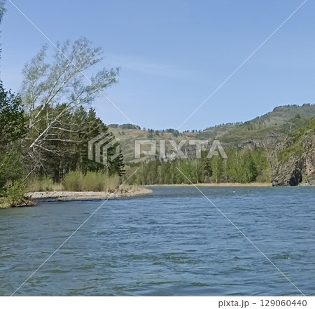 Scenic Mountain River Landscape with Lush Forest and Clear Blue Sky for Outdoor Adventure 129060440