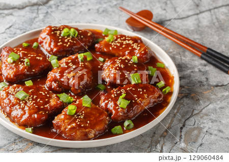 Sweet and sour pork chops are delicious and covered in a glaze made out of brown sugar, soy sauce, hoisin and Worcestershire sauce closeup on the plate. Horizontal Sweet and sour pork chops are delicious and covered in a glaze made out of brown sugar, soy sauce, hoisin and Worcestershire sauce closeup on the plate. Horizontal 129060484