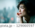 窓辺で物思いにふける女性のポートレート｜都会の景色とアンニュイな表情1 129060597