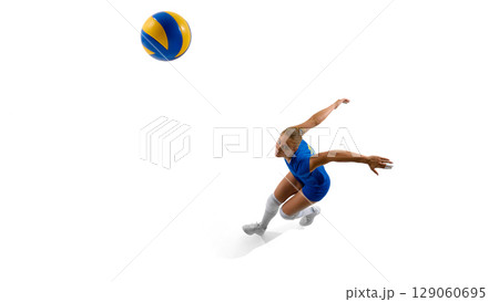 Female volleyball player in blue outfit jumping to hit ball Female volleyball player in blue outfit jumping to hit ball 129060695