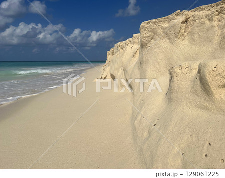 Golden sand shaped by waves on a tropical Aruba beach 129061225