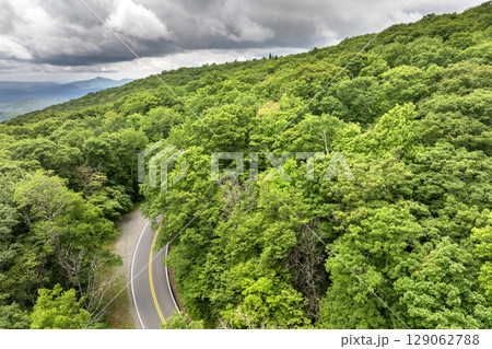 Road trip driving in Tennessee Appalachian mountains. Winding parkway in mountain forest with green canopies in summer rain season 129062788