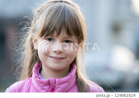 Portrait of happy child girl in warm clothes in autumn outdoors. 129062829