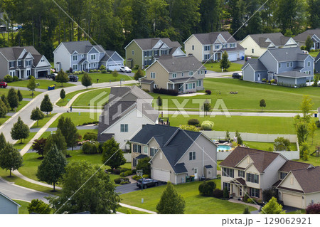 Low-density two story private homes in rural residential suburbs outside of Rochester, New York. Upscale suburban houses with large lot size and green grassy lawns in summer season 129062921