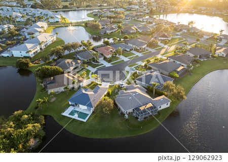 Low-density private homes at sunset. Rural street cul-de-sac dead end in residential suburbs with upscale suburban houses outside of Sarasota, Florida 129062923