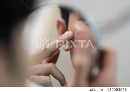 Self-Care Routine: Man Applying Skincare in Mirror Reflection 129063058