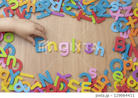 子供の手がアルファベットを並べる英語学習の様子 子供の手がアルファベットを並べる英語学習の様子 129064411