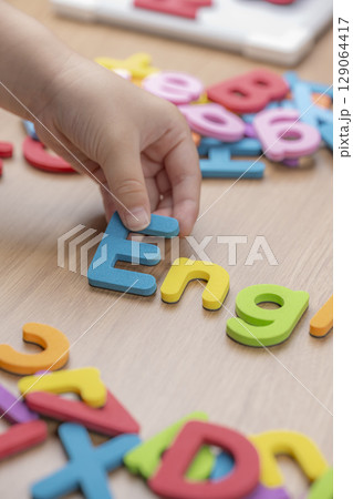 子供の手がアルファベットを並べる英語学習の様子 129064417