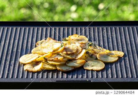 sliced potatoes with oil on hot grill pan sliced potatoes with oil on hot grill pan 129064484
