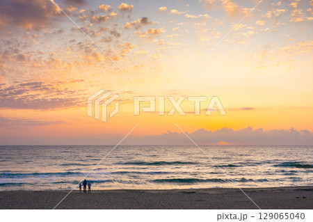 sunrise at the sea in summer with sun and cloudscape above horizon. calm travel background at dawn. dramatic weather sunrise at the sea in summer with sun and cloudscape above horizon. calm travel background at dawn. dramatic weather 129065040