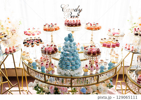 Candy bar showing macarons, cupcakes, and pastries during a celebration Candy bar showing macarons, cupcakes, and pastries during a celebration 129065111