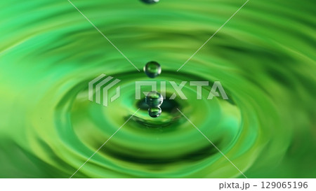 Green Water drop falling, macro splash. Natural background. Green Water drop falling, macro splash. Natural background. 129065196