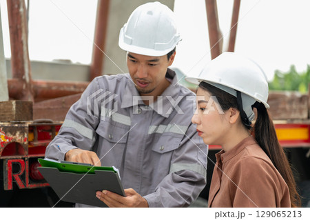 Engineers are discussing building a house with precast materials at a construction site. Engineers are discussing building a house with precast materials at a construction site. 129065213
