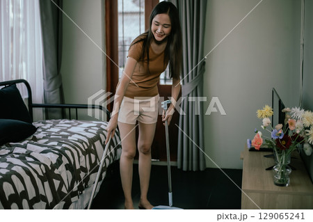 Asian woman cleaning the house. Asian woman cleaning the house. 129065241