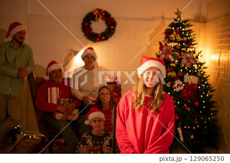 A joyful family gathering during Christmas celebrations, adorned with festive hats and a beautifully decorated tree. A joyful family gathering during Christmas celebrations, adorned with festive hats and a beautifully decorated tree. 129065250