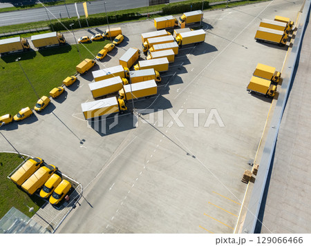 Delivery vans and trucks hub. Fleet of yellow post vehicles. 129066466