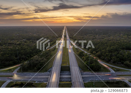 Highway intersection in Florida rural area at sunset. Elevated interchange lanes for express passing of car traffic 129066873