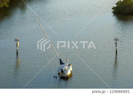 Half sunken sailing yacht capsized on shallow bay waters after hurricane Ian in Manasota, Florida 129066891