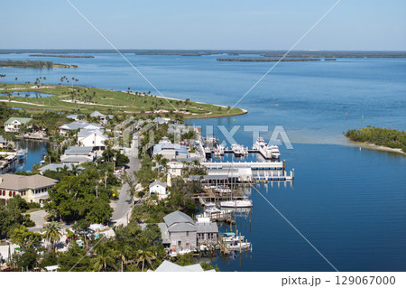 Expensive mansions between green palm trees on Gulf of Mexico shore in island small town Boca Grande on Gasparilla Island in southwest Florida, USA. Aerial view of wealthy waterfront neighborhood Expensive mansions between green palm trees on Gulf of Mexico shore in island small town Boca Grande on Gasparilla Island in southwest Florida, USA. Aerial view of wealthy waterfront neighborhood 129067000