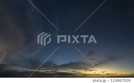 Dramatic sunset sky covered with colorful yellow clouds. Panoramic skyscape 129067026