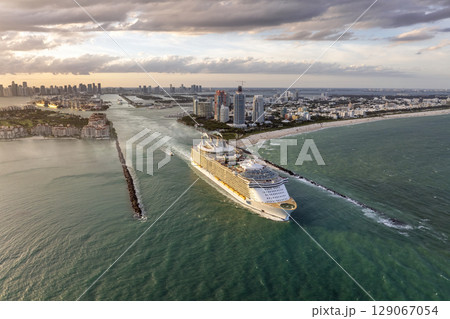 Cruise ship leaving Miami harbor main channel near South Beach. Luxurious hotels and apartment buildings on waterfront and high skyscrapers of downtown district in distance Cruise ship leaving Miami harbor main channel near South Beach. Luxurious hotels and apartment buildings on waterfront and high skyscrapers of downtown district in distance 129067054