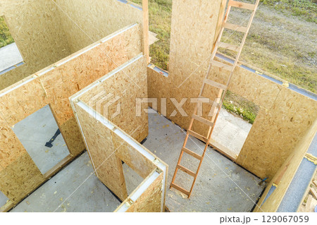 Construction of new and modern modular house. Walls made from composite wooden sip panels with styrofoam insulation inside. Building new frame of energy efficient home concept. Construction of new and modern modular house. Walls made from composite wooden sip panels with styrofoam insulation inside. Building new frame of energy efficient home concept. 129067059