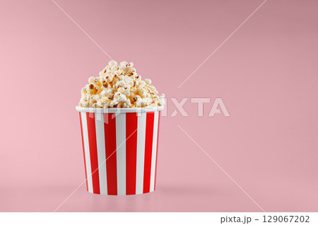 Classic red striped popcorn cardboard cup on Red background Classic red striped popcorn cardboard cup on Red background 129067202