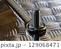 Tightening Nut On Bolt With Chrome Spanner 129068471