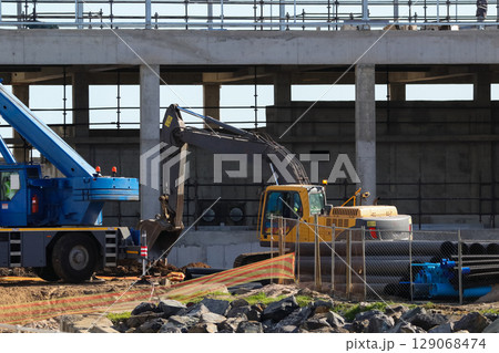 Heavy Machinery Working On Building Construction Site 129068474