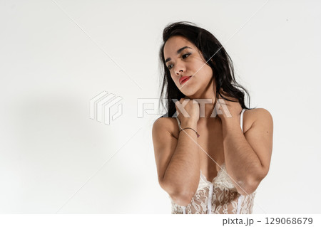Pensive latin woman touching neck expressing sadness and worry Pensive latin woman touching neck expressing sadness and worry 129068679