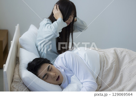 ベッドでいびきをかきながら眠る若い男性　 129069564