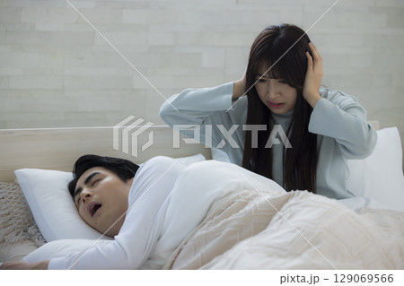 ベッドでいびきをかきながら眠る若い男性　 129069566