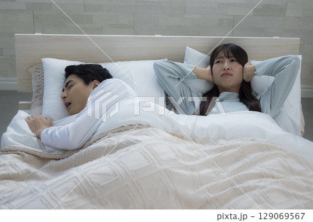 ベッドでいびきをかきながら眠る若い男性　 129069567