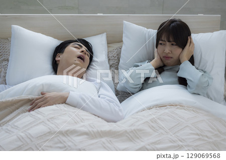 ベッドでいびきをかきながら眠る若い男性　 129069568