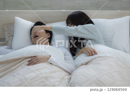 ベッドでいびきをかきながら眠る若い男性　 129069569