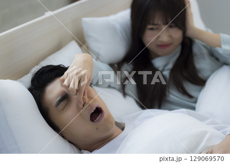 ベッドでいびきをかきながら眠る若い男性 ベッドでいびきをかきながら眠る若い男性 129069570