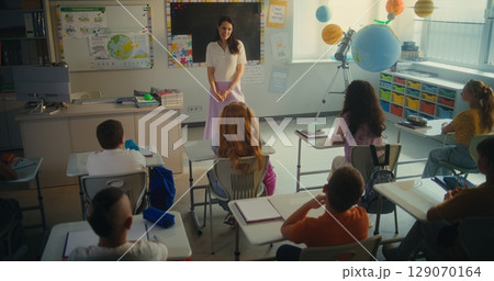 Female Teacher Educating Ecology to Smart Kids. Primary School Children Raising Hands to Give Answer Female Teacher Educating Ecology to Smart Kids. Primary School Children Raising Hands to Give Answer 129070164
