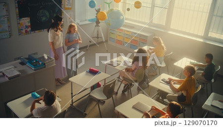 STEM Class: Diverse Kids Raising Hands to Give Answer, Smart Girl Going to Board and Presenting Homework 129070170