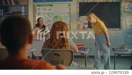 Elementary School Girl Presenting Homework on Ecology in Front of Classmates and Female Teacher Elementary School Girl Presenting Homework on Ecology in Front of Classmates and Female Teacher 129070189