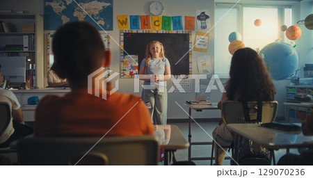 Talented Girl Talking, Presenting Homework in Front of Classroom Full of Classmates 129070236