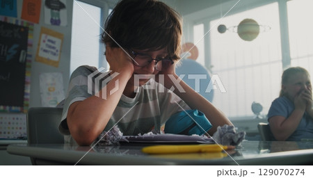 Stressed Primary School Boy Sitting Alone While Aggressive Classmates Abusing Him and Laughing 129070274
