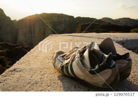 夕暮れ時の眩しい日差しがあたるボロボロのウォーキングシューズ 夕暮れ時の眩しい日差しがあたるボロボロのウォーキングシューズ 129070517