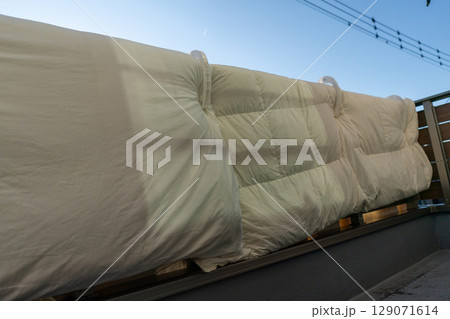 家のベランダの手すりに布団を干す 129071614
