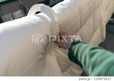 家のベランダの手すりに布団を干す 129071621