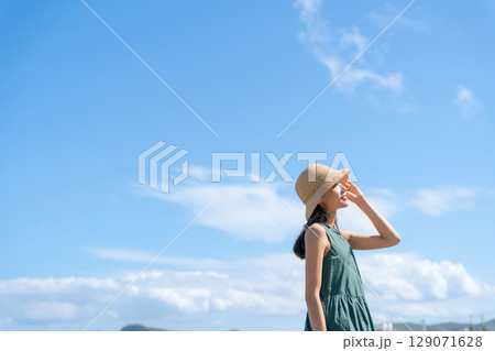 夏の浜辺に立つワンピースの女性 夏の浜辺に立つワンピースの女性 129071628