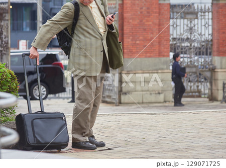 京都国立博物館の広場にいるスーツケースを持つ男性サラリーマンの姿 129071725