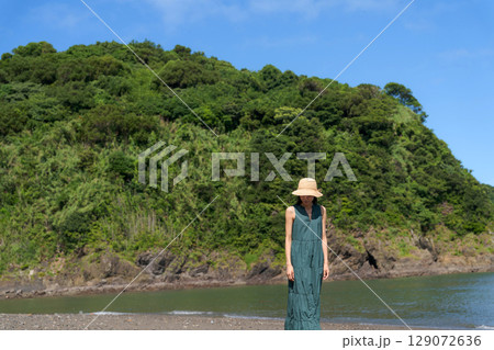 夏の浜辺に立つワンピースの女性 129072636