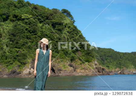 夏の浜辺に立つワンピースの女性 夏の浜辺に立つワンピースの女性 129072638