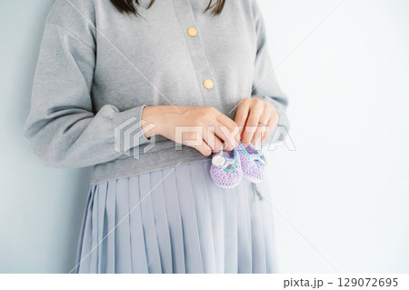 手編みのベビーシューズを持つ出産間近の妊婦 129072695